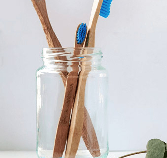 a group of toothbrushes in a glass jar